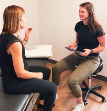 Instructor sitting on a chair talking to her cl
